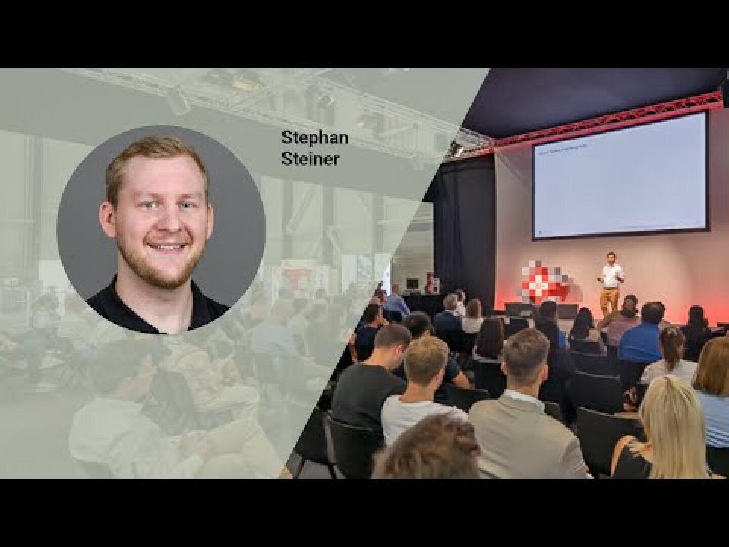 Ein Mann namens Stephan Steiner spricht auf der Bühne zu einem Publikum in einem modernen Veranstaltungsraum. Sein Porträt und sein Name erscheinen überlagert auf der linken Seite des Bildes.