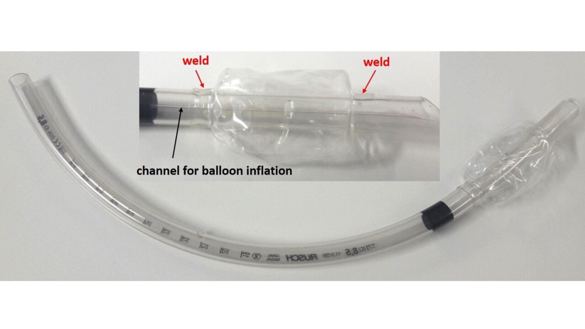 A clear medical tube with measurement markings, featuring an inflatable balloon near one end. An inset shows a close-up of the balloon with arrows pointing to welds and a labeled channel for balloon inflation.