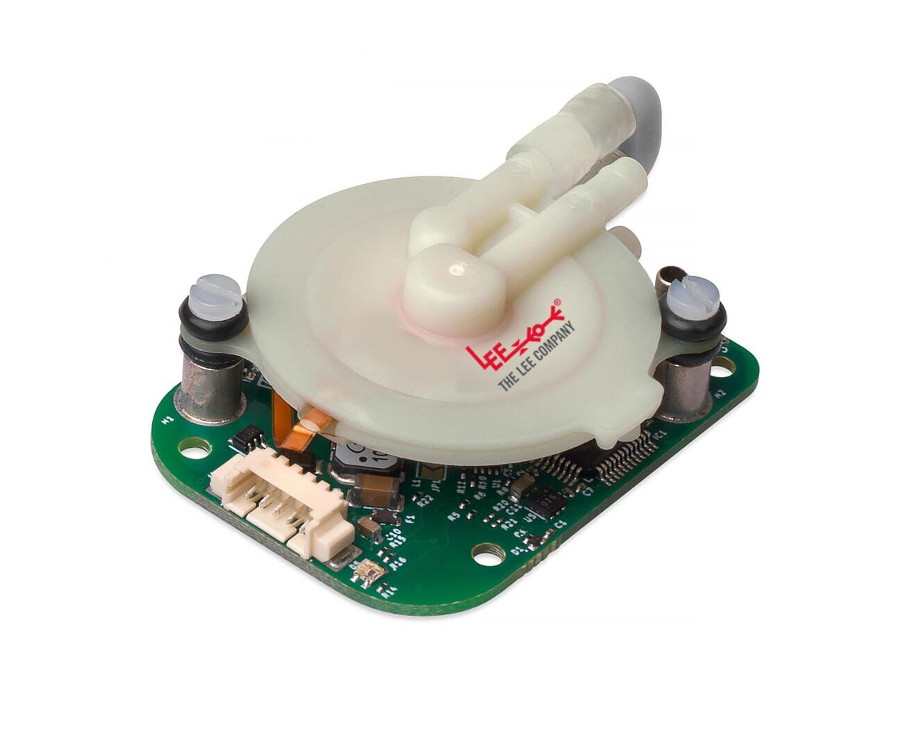 Ein rundes, weißes Flüssigkeitsbauteil aus Kunststoff mit zwei Schlauchanschlüssen ist auf einer grünen Leiterplatte mit elektronischen Bauteilen montiert. Das Logo LEE COMPANY ist in roter Farbe auf dem weißen Teil aufgedruckt.