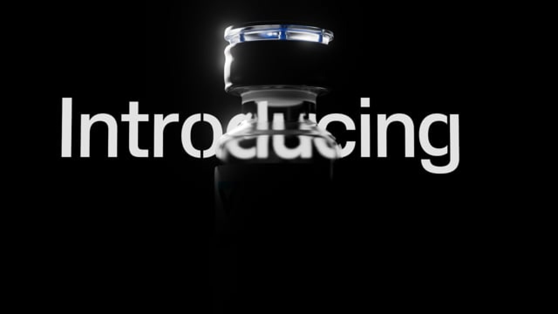 A medication bottle is dramatically illuminated against a black background. The word Introducing is superimposed in large white letters, partially obscured by the silhouette of the bottle.