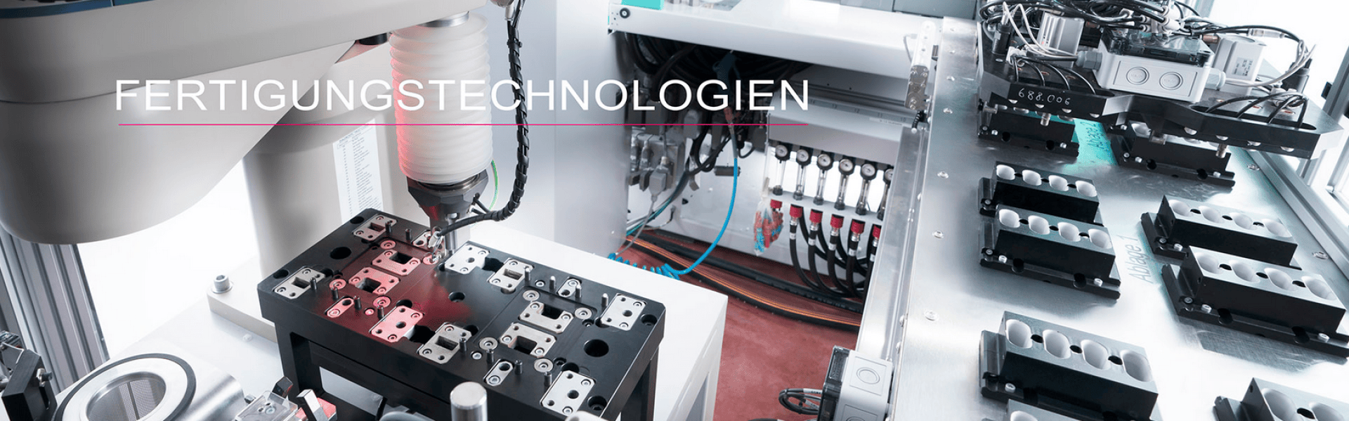Ein Roboterarm montiert Metallkomponenten an einer Produktionslinie in einer modernen, automatisierten Fabrik. Über dem Bild ist das deutsche Wort „FERTIGUNGSTECHNOLOGIEN“ zu sehen.