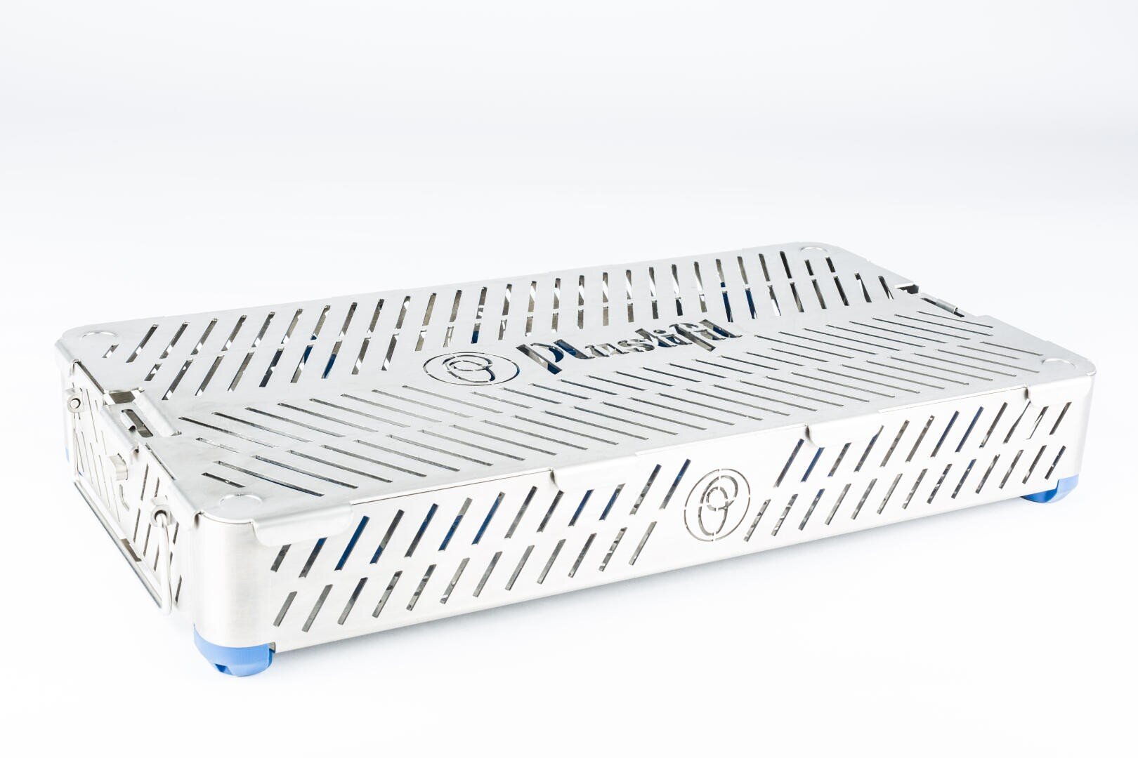 A rectangular, silver metal sterilization container with diagonal slits, blue corner feet, and the word Plus on the lid, used for holding medical instruments.