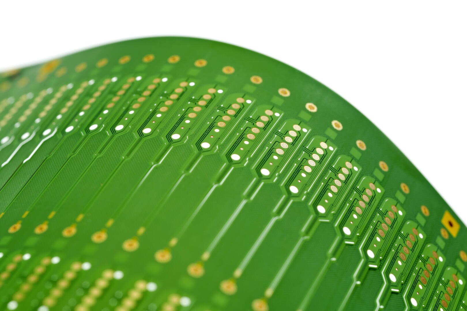 Nahaufnahme einer gebogenen grünen Leiterplatte mit goldenen Kontaktpunkten und komplizierten Linien, die elektronische Pfade und Komponenten vor einem weißen Hintergrund darstellen.